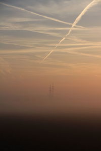 Vapor trail in sky during sunset