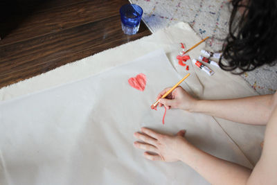 High angle view of woman hand holding paper on table