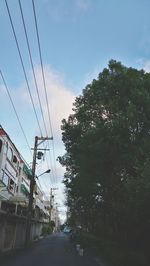 Road amidst trees against sky in city