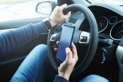 Midsection of woman driving car