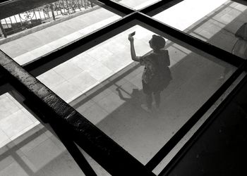 High angle view of woman standing on escalator