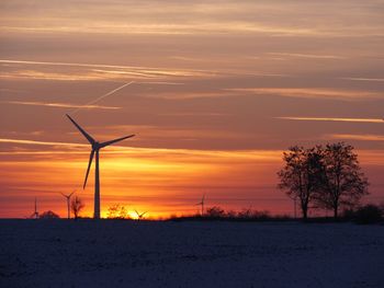 Silhouette of wind turbines at sunset