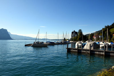 Sailing boats resting in the port of vitznau on lake lucerne with view of mountain ranges