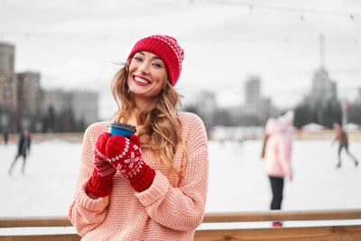 Portrait of smiling woman standing in snow