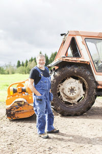 Senior man in front of tractor, smaland, sweden