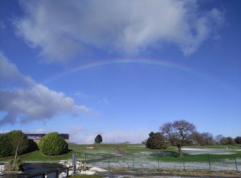 Scenic view of rainbow over landscape against sky