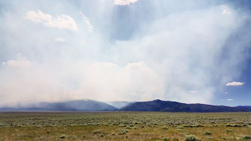 Panoramic view of agricultural field against sky