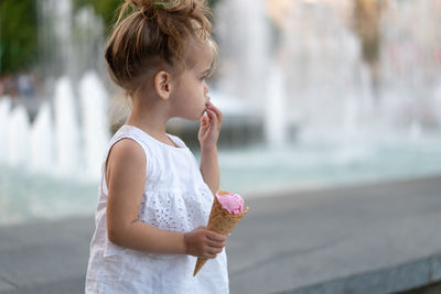 Cute girl looking away while holding ice cream