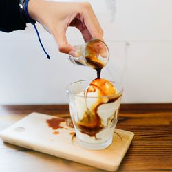 Cropped image of hand pouring coffee in cup on table