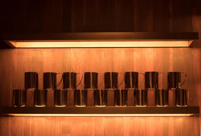 Mugs arranged side by side on shelf
