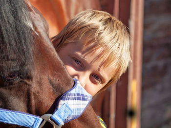 Close-up portrait of boy holding camera