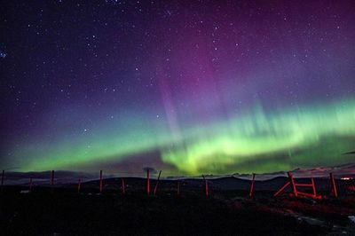 Scenic view of landscape against star field at night