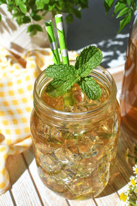 Close-up of iced tea drink with mint in glass on table