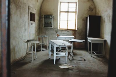 Empty chairs and table in abandoned room