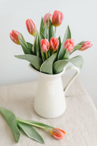 Bouquet of delicate pink tulips in a jug.