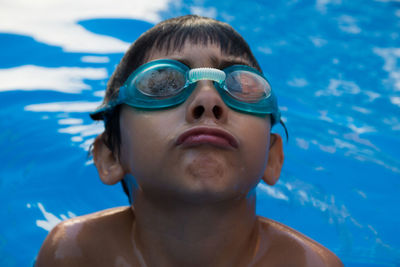 Close-up portrait of shirtless boy swimming in pool