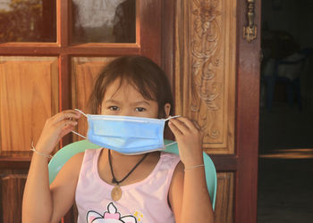 Portrait of girl wearing mask at home