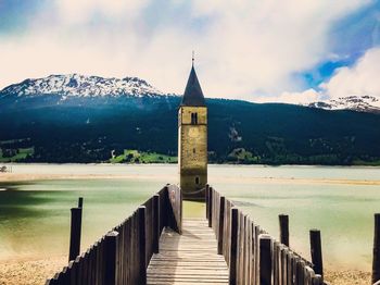 Building by lake against sky