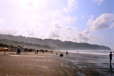 People on beach against sky