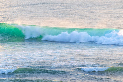 Turquoise sea wave with the tide, lit by the sunlight. photo with blur in motion.