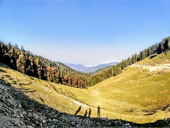 Scenic view of landscape and mountains against clear sky