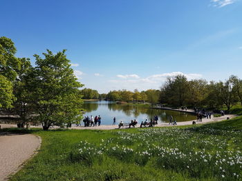 People in park by river against sky