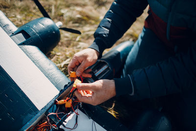 Midsection of man using mobile phone outdoors