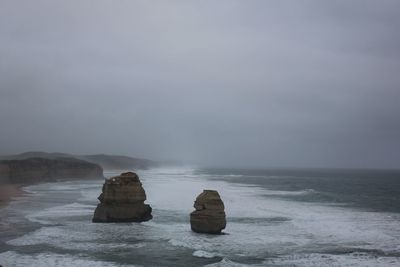 Rocks in sea against sky