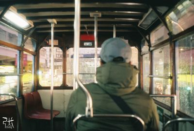 Rear view of woman sitting in bus