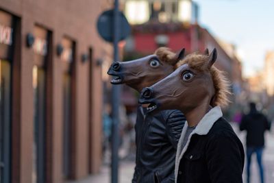 People wearing horse pattern mask in city