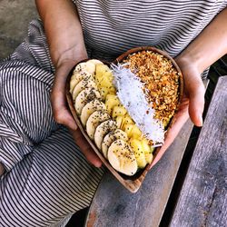 High angle view of person holding bowl of muesli