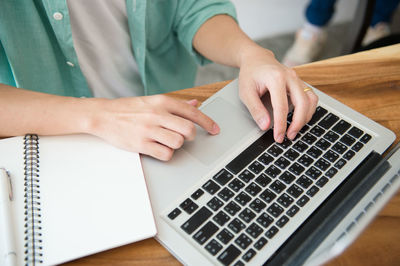 Midsection of man using laptop on table