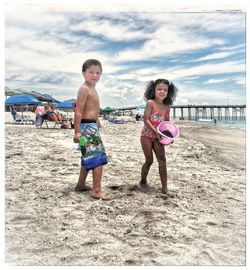 Full length of children on beach against sky