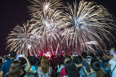 Low angle view of firework display at night