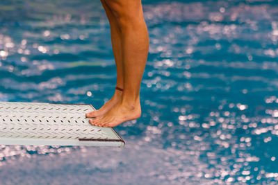 Low section of woman standing in swimming pool