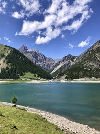 Scenic view of lake by mountains against sky
