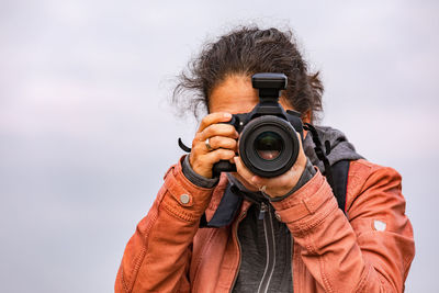 Man photographing against sky