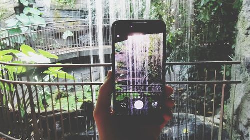 Close-up of man photographing through mobile phone