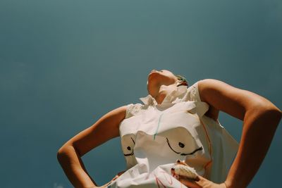 Low angle view of woman standing against sky