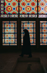 Low angle view of woman walking in window of building