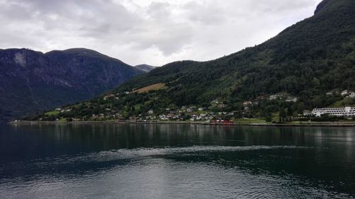 Scenic view of lake by mountains against sky