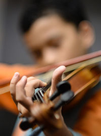 Close-up of boys hand playing the violin