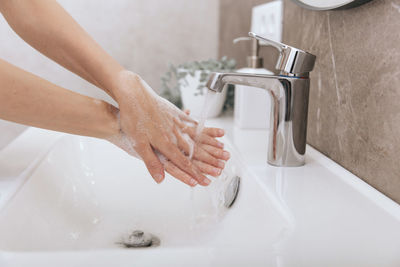 Midsection of woman in bathroom at home