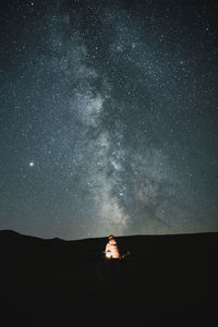 Scenic view of star field against sky at night. lightened silhouette against milky way.