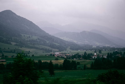 Scenic view of field and mountains against sky