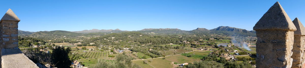 Panoramic view of landscape against clear blue sky