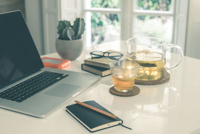 Morning time at home healthy breakfast laptop and cup of lemon tea on table. natural meal at work