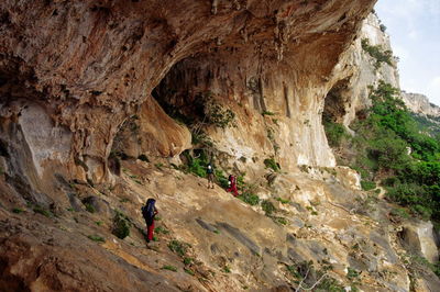 Rear view of man and woman on cliff against mountain