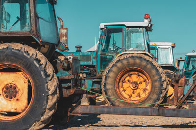 Close-up of tractor on agricultural field against sky