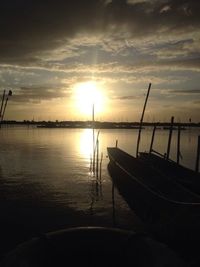 Boats in calm sea at sunset